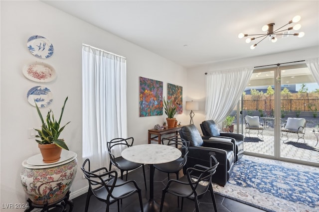 dining area featuring dark tile patterned flooring and a notable chandelier