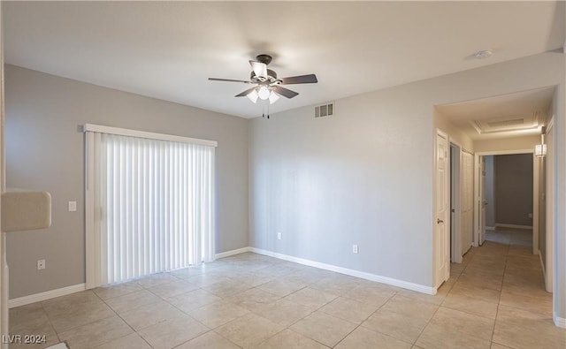 tiled spare room with ceiling fan