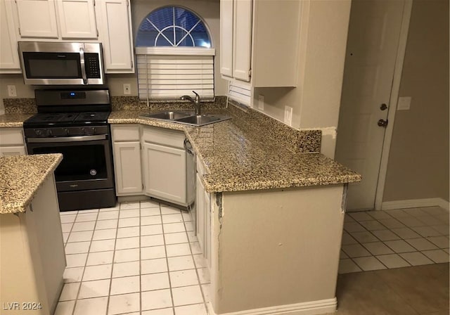 kitchen featuring white cabinets, appliances with stainless steel finishes, light tile patterned flooring, and sink