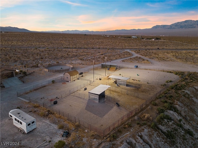 aerial view at dusk with a mountain view, a rural view, and view of desert