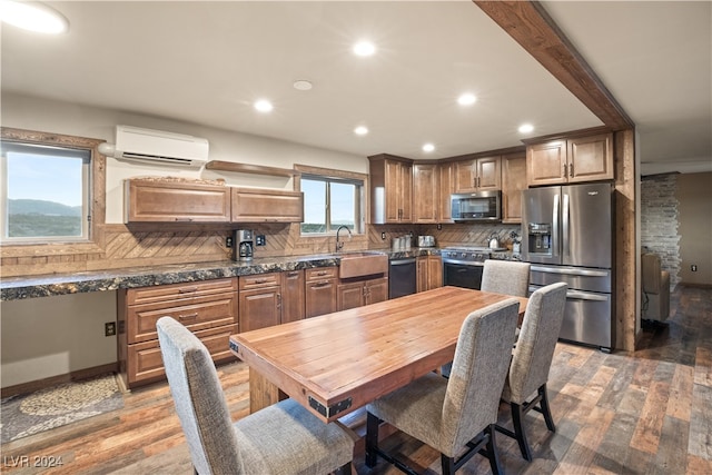 kitchen with light wood finished floors, recessed lighting, a wall mounted air conditioner, appliances with stainless steel finishes, and tasteful backsplash