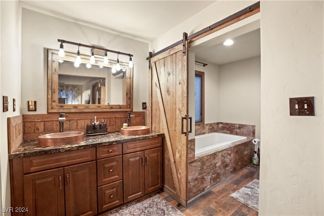 bathroom featuring a sink, a bath, and double vanity