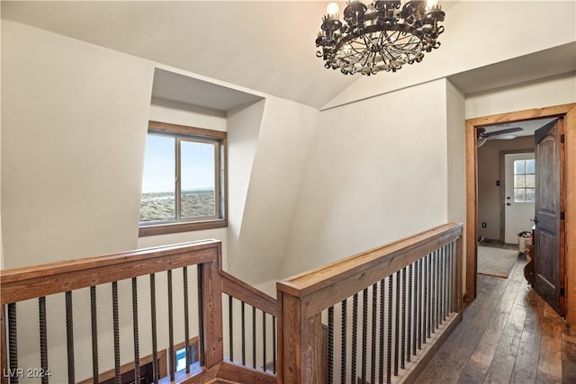 hall featuring a chandelier, lofted ceiling, an upstairs landing, and hardwood / wood-style flooring