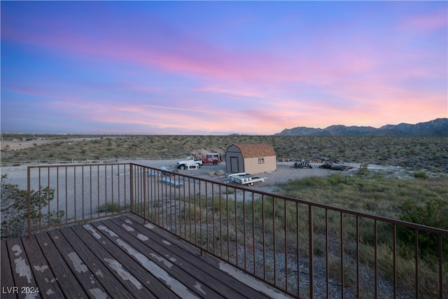 deck featuring an outbuilding, a mountain view, and a storage shed