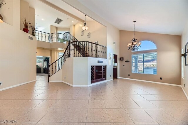 unfurnished living room featuring beam ceiling, light tile patterned floors, high vaulted ceiling, and a chandelier