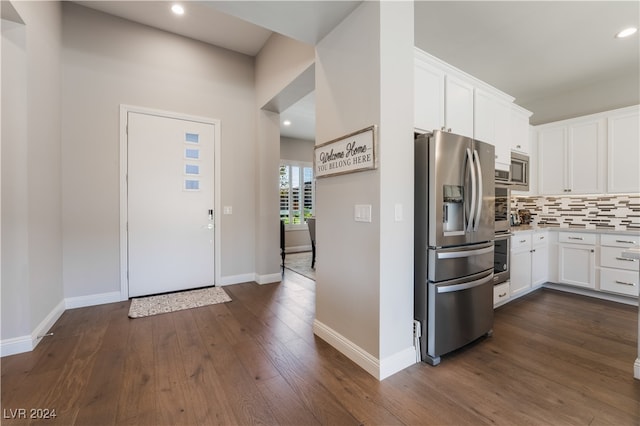 kitchen featuring decorative backsplash, appliances with stainless steel finishes, dark hardwood / wood-style floors, and white cabinetry