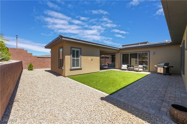 rear view of house featuring a lawn, outdoor lounge area, and a patio