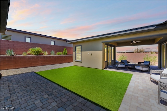 yard at dusk with a patio area, ceiling fan, and an outdoor hangout area