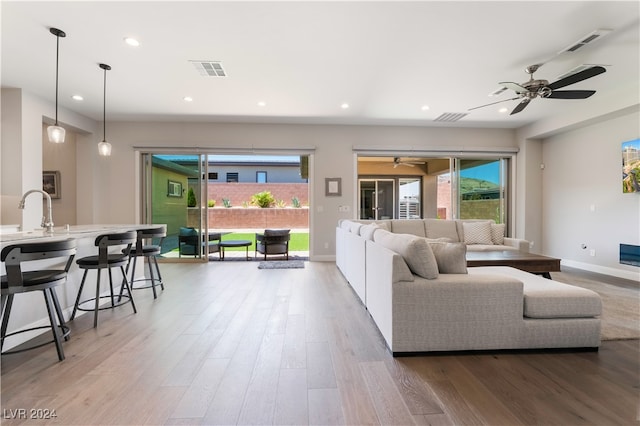 living room featuring ceiling fan and light wood-type flooring