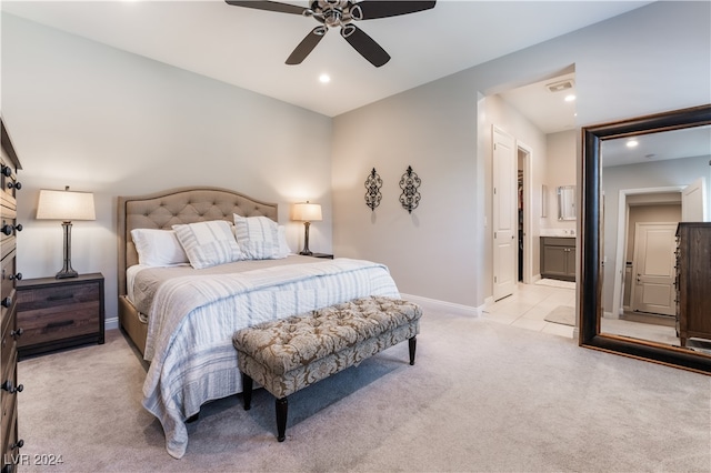 bedroom with ceiling fan, light carpet, and connected bathroom