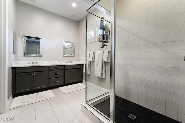 bathroom featuring tile patterned flooring, a tile shower, and vanity