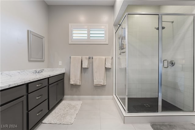 bathroom featuring tile patterned floors, a shower with door, and vanity