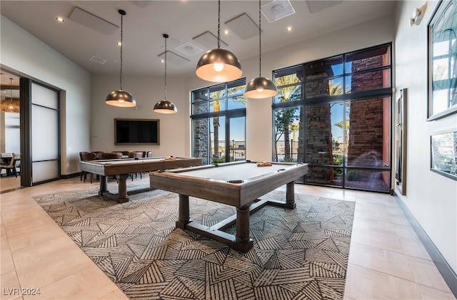 recreation room with light tile patterned flooring, a towering ceiling, a wealth of natural light, and billiards