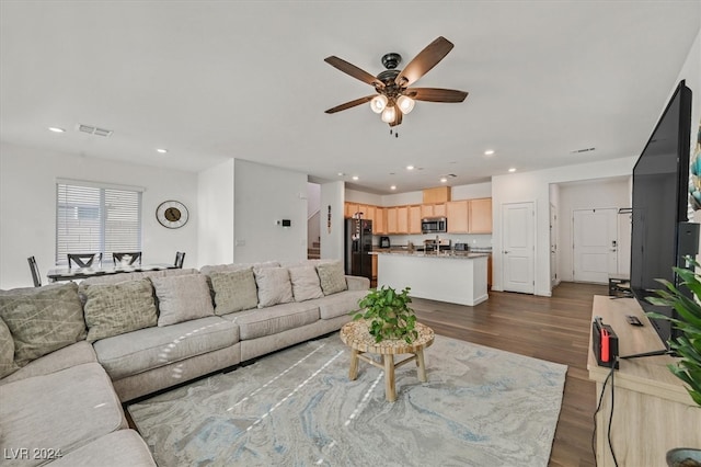 living room with ceiling fan and dark hardwood / wood-style flooring