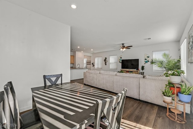 dining space featuring dark hardwood / wood-style flooring, ceiling fan, and sink