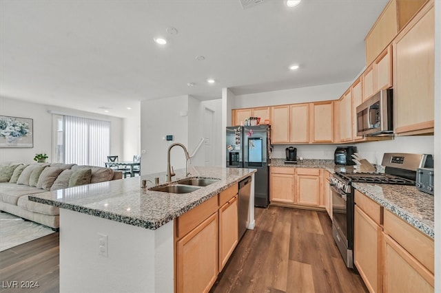 kitchen featuring appliances with stainless steel finishes, light brown cabinetry, a kitchen island with sink, sink, and dark hardwood / wood-style floors