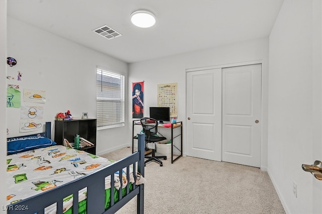 bedroom featuring a closet and light colored carpet