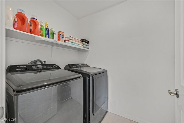 laundry area featuring light tile patterned floors and washer and clothes dryer