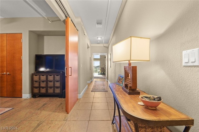 corridor featuring light tile patterned flooring and ornamental molding