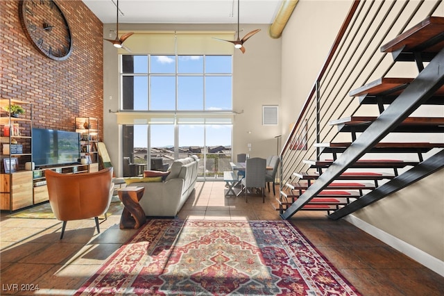 living room with ceiling fan and a high ceiling