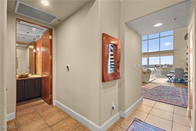 corridor with light tile patterned floors and sink