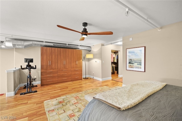 bedroom featuring a walk in closet, ceiling fan, a closet, and hardwood / wood-style flooring