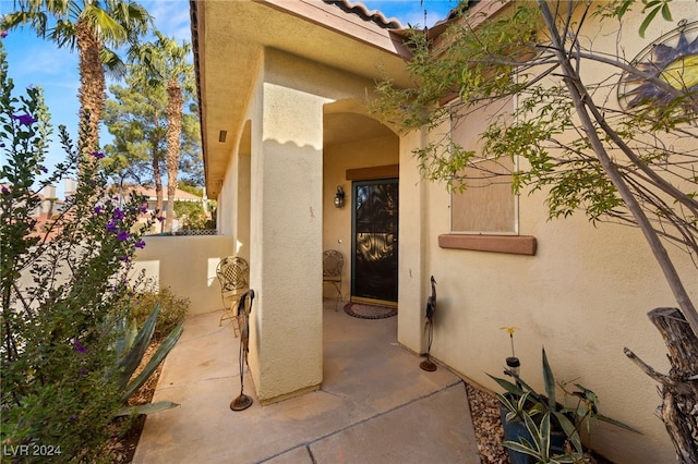 view of exterior entry featuring a patio