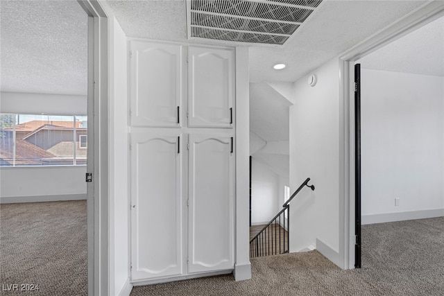 interior space featuring carpet and a textured ceiling