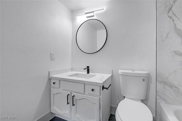 bathroom with a tub to relax in, vanity, and toilet