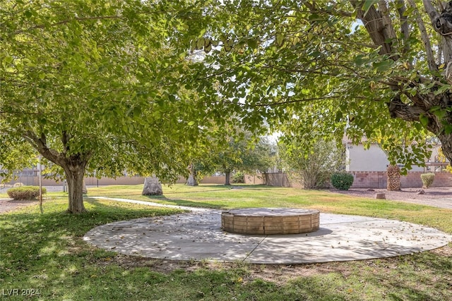 view of property's community featuring an outdoor fire pit and a lawn