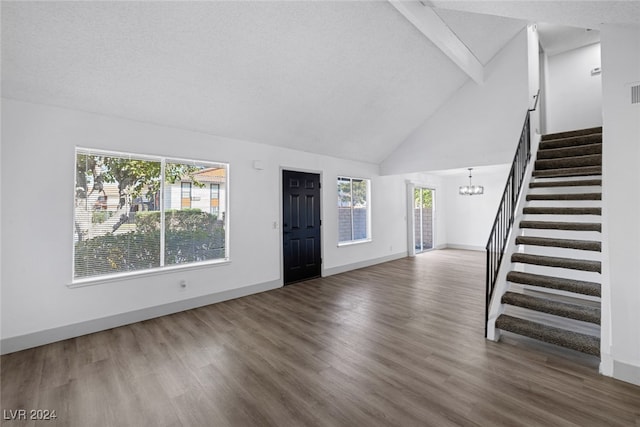 foyer with a textured ceiling, hardwood / wood-style flooring, high vaulted ceiling, and a notable chandelier