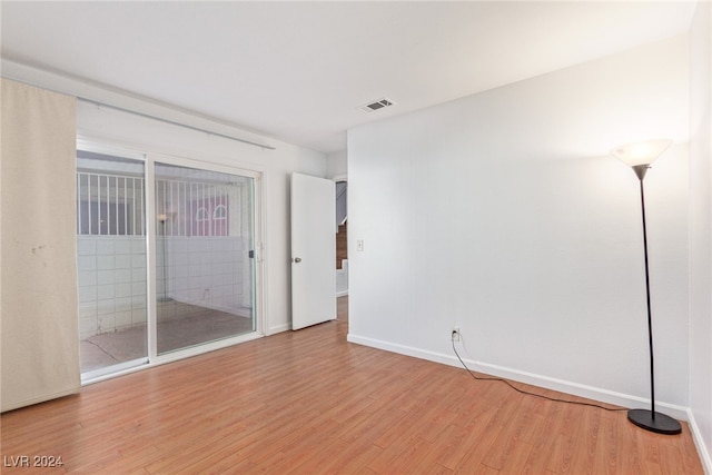 unfurnished bedroom with access to exterior and light hardwood / wood-style flooring