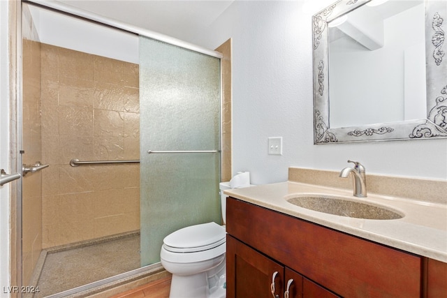 bathroom featuring wood-type flooring, vanity, toilet, and a shower with shower door