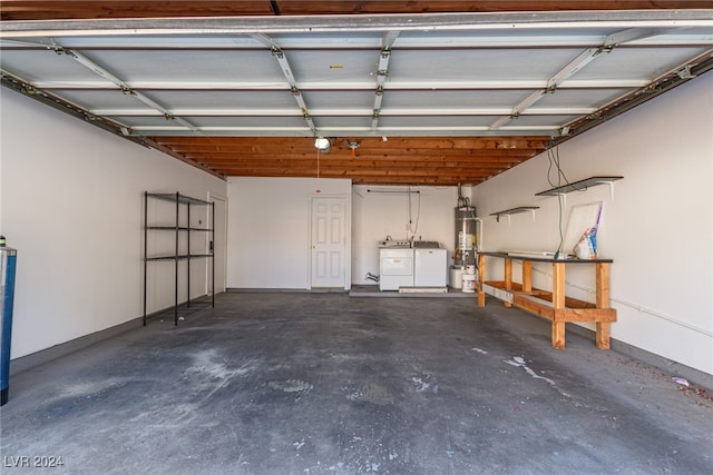 garage with washing machine and clothes dryer and secured water heater