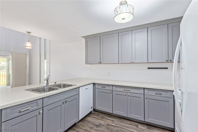 kitchen with white appliances, decorative light fixtures, gray cabinetry, and sink