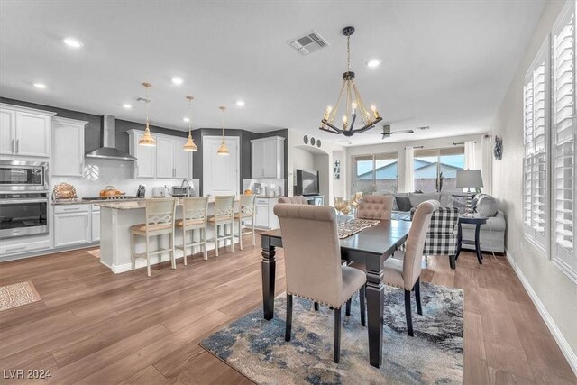 dining space with a notable chandelier and light wood-type flooring