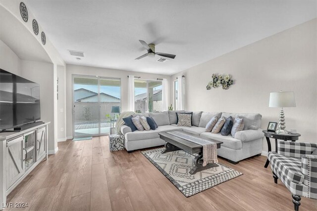 living room with light hardwood / wood-style floors and ceiling fan