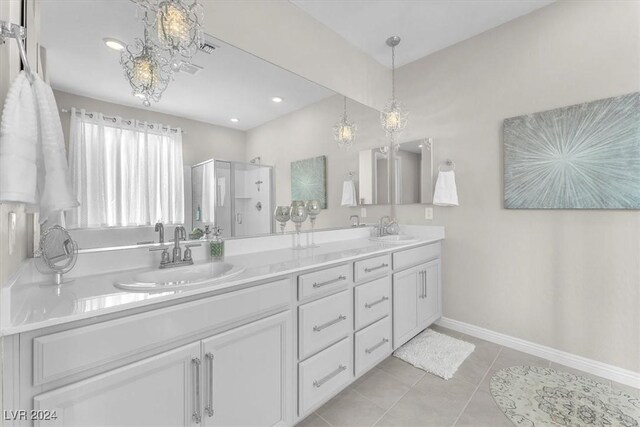 bathroom featuring vanity, a shower with shower door, and tile patterned flooring