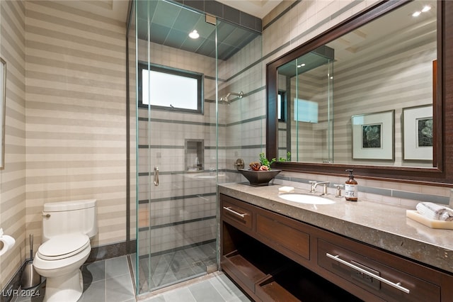 bathroom with tile patterned flooring, vanity, toilet, and a shower with shower door