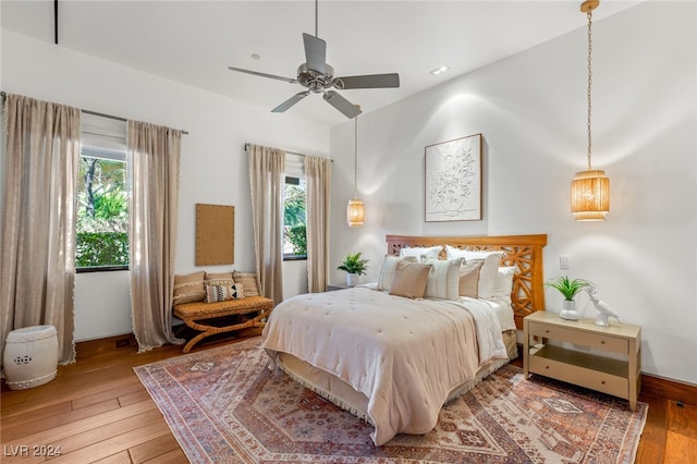 bedroom with multiple windows, ceiling fan, and hardwood / wood-style flooring