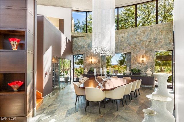 dining space with a notable chandelier and a wall of windows