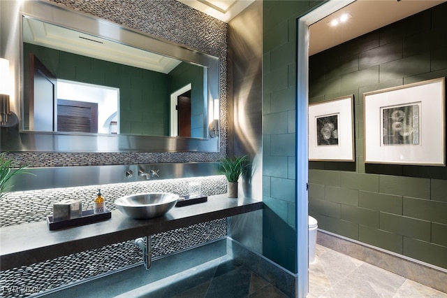 bathroom featuring tile patterned floors, toilet, tile walls, and ornamental molding