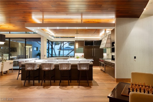 kitchen featuring a kitchen bar, light hardwood / wood-style floors, double oven range, and wooden ceiling