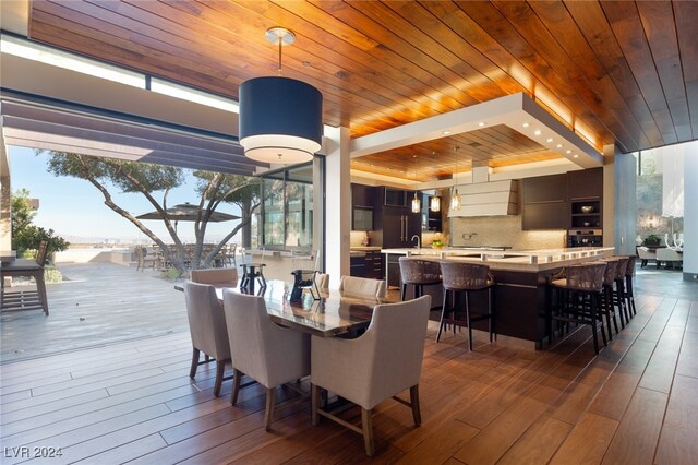 dining room with beamed ceiling, wood ceiling, and dark hardwood / wood-style floors