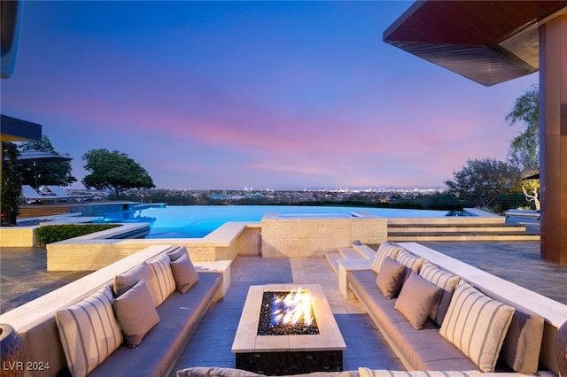 patio terrace at dusk featuring an outdoor living space with a fire pit