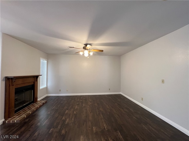 unfurnished living room featuring ceiling fan, dark hardwood / wood-style floors, and a brick fireplace