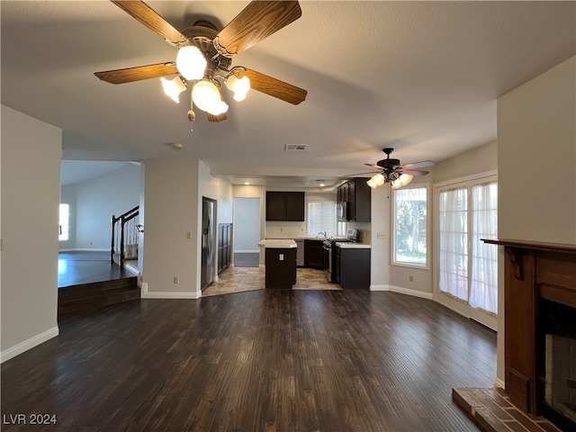 unfurnished living room with dark hardwood / wood-style floors and ceiling fan