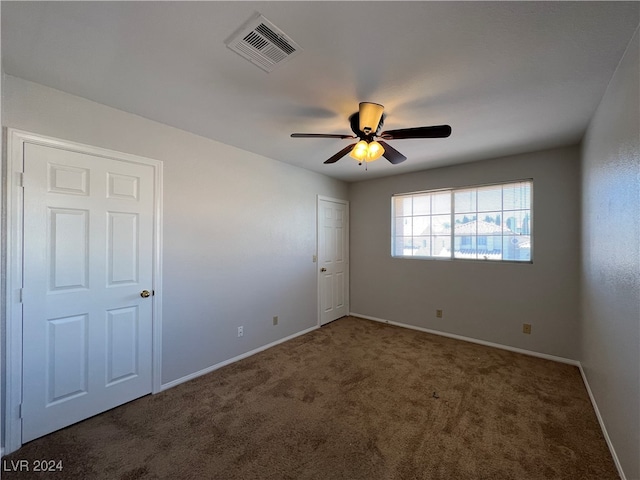 carpeted spare room featuring ceiling fan