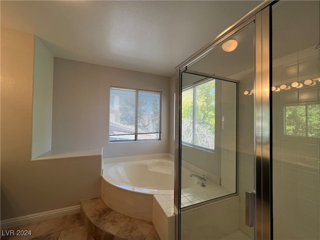 bathroom featuring tile patterned flooring, shower with separate bathtub, and a textured ceiling