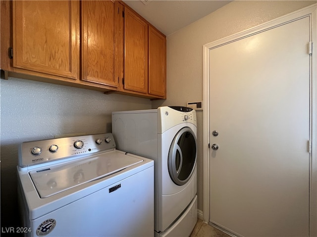 washroom with light tile patterned floors, cabinets, and independent washer and dryer